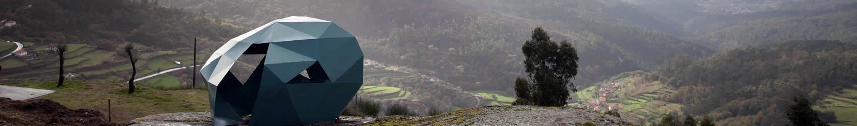 Na imagem vê-se uma instalação artística que faz lembrar um casulo no cimo de um monte